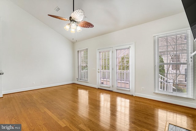 spare room with a ceiling fan, wood finished floors, baseboards, visible vents, and lofted ceiling