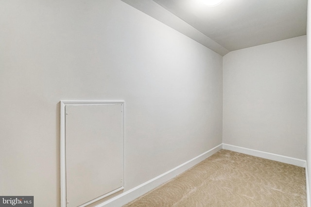 carpeted spare room featuring baseboards