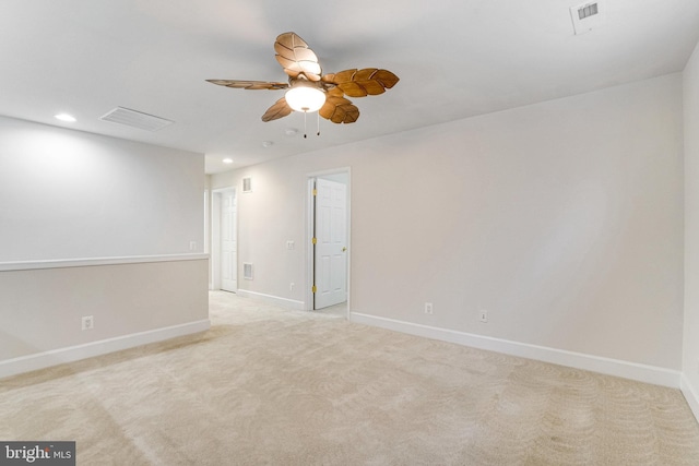 unfurnished room featuring visible vents, light colored carpet, baseboards, and ceiling fan