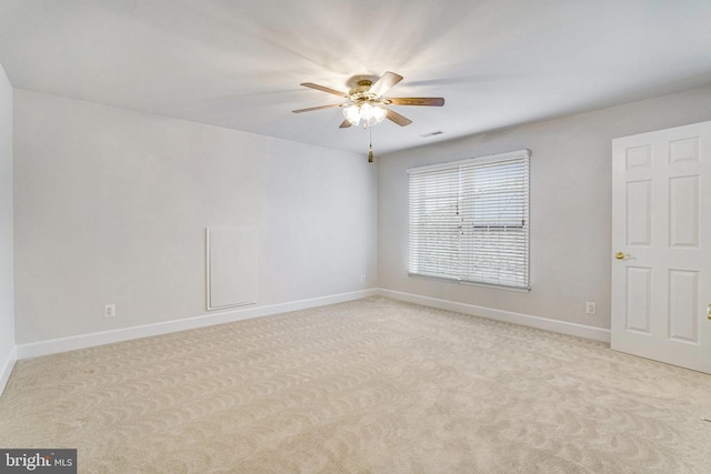 unfurnished room with light carpet, visible vents, baseboards, and a ceiling fan