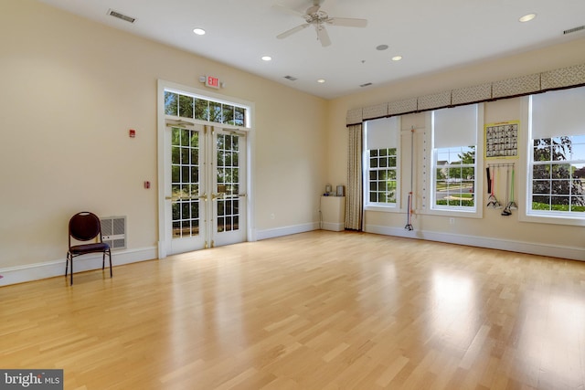 spare room with a ceiling fan, visible vents, baseboards, light wood-style floors, and french doors