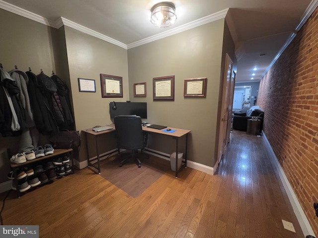 office space featuring ornamental molding, brick wall, and light hardwood / wood-style flooring