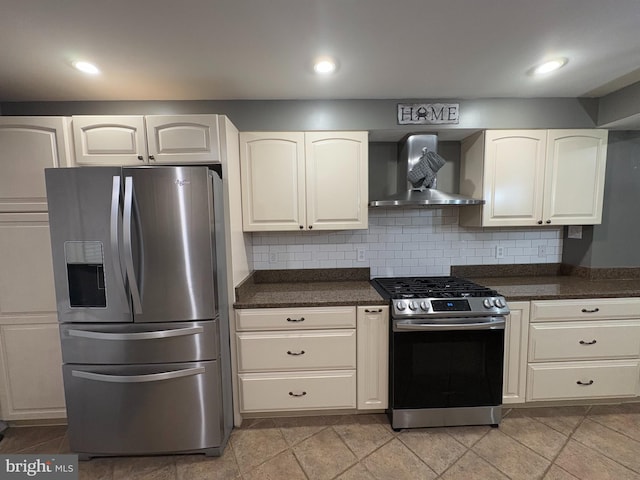 kitchen featuring tasteful backsplash, white cabinets, wall chimney exhaust hood, and stainless steel appliances