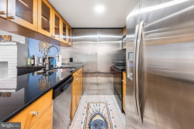 kitchen featuring light tile patterned floors, sink, appliances with stainless steel finishes, and dark stone counters