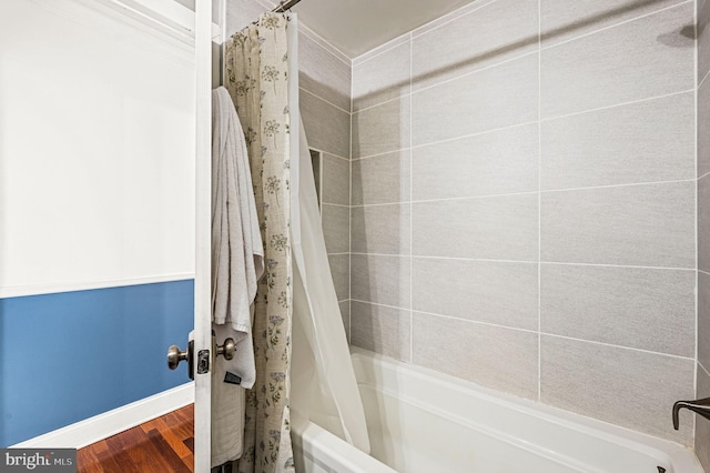 bathroom featuring hardwood / wood-style floors and shower / bathtub combination with curtain