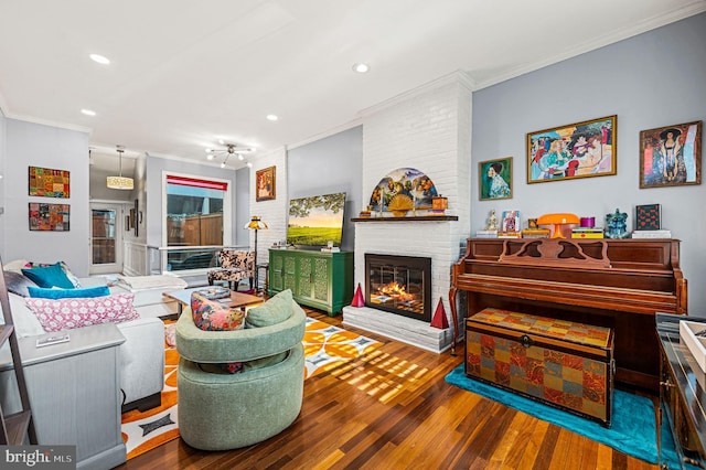 living room featuring crown molding, a fireplace, and hardwood / wood-style flooring