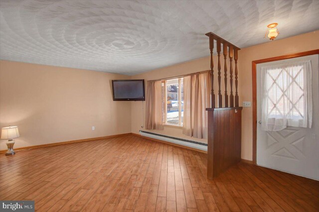 foyer entrance with a baseboard radiator and hardwood / wood-style flooring