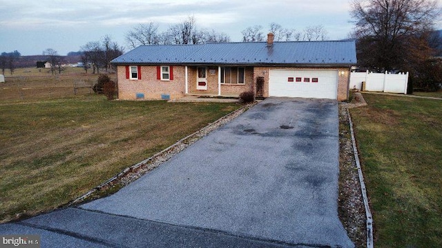 ranch-style house featuring a front yard and a garage