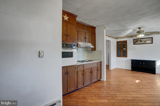 kitchen featuring white appliances, ceiling fan, light hardwood / wood-style flooring, and backsplash