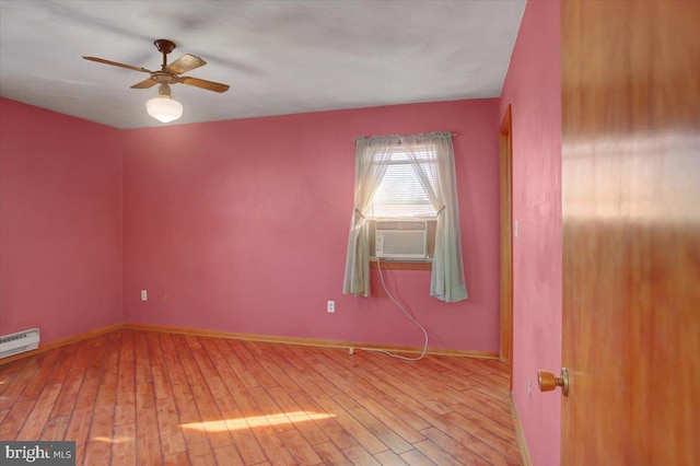 spare room featuring cooling unit, baseboard heating, ceiling fan, and light hardwood / wood-style flooring