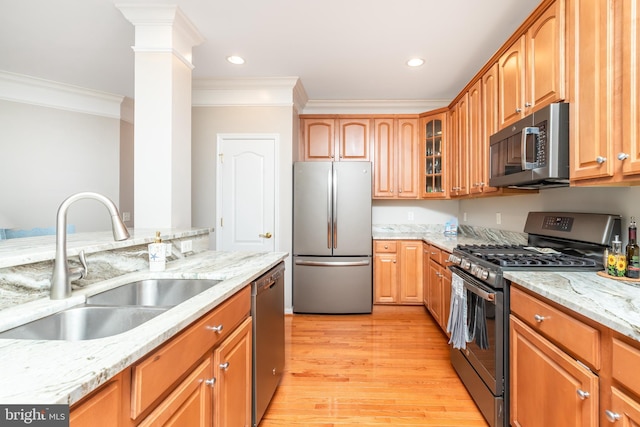 kitchen featuring ornate columns, sink, light hardwood / wood-style floors, stainless steel appliances, and light stone countertops