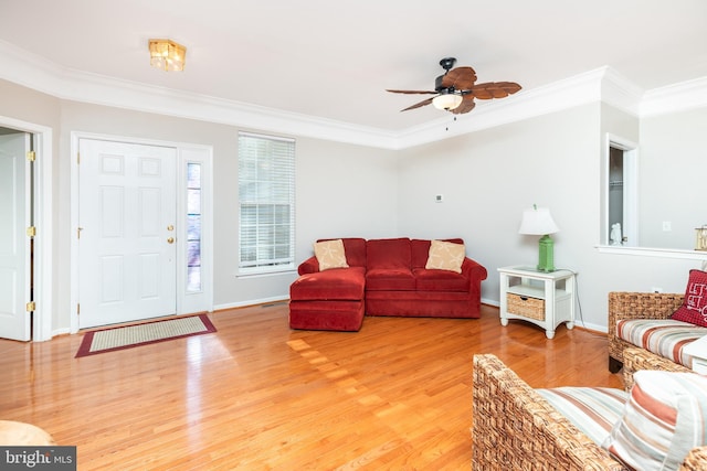 living room with crown molding, wood-type flooring, and ceiling fan