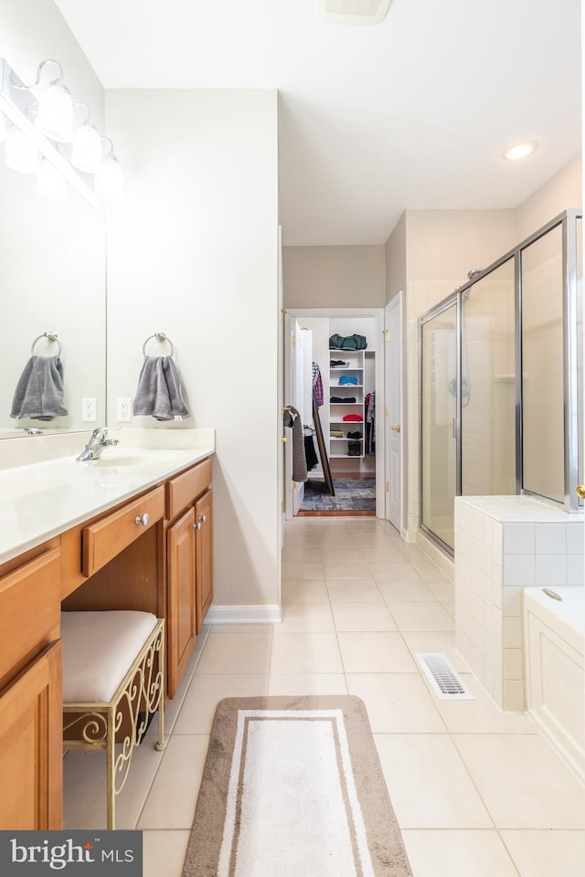 bathroom featuring tile patterned flooring, vanity, and shower with separate bathtub