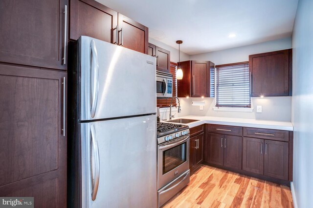 1427 Paul Blvd, Manahawkin, NJ 08050 - kitchen featuring decorative light fixtures, light countertops, light wood-type flooring, appliances with stainless steel finishes, and a sink