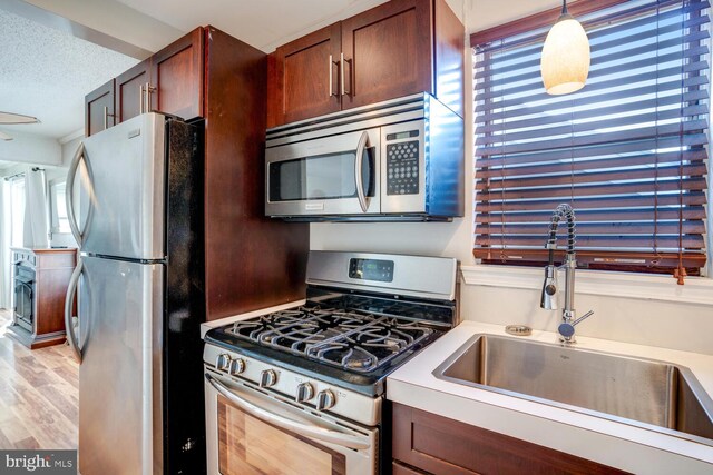 1427 Paul Blvd, Manahawkin, NJ 08050 - kitchen featuring a healthy amount of sunlight, light wood-style flooring, appliances with stainless steel finishes, a textured ceiling, and a sink