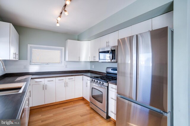 1427 Paul Blvd, Manahawkin, NJ 08050 - kitchen featuring a sink, stainless steel appliances, light wood-style floors, and dark countertops