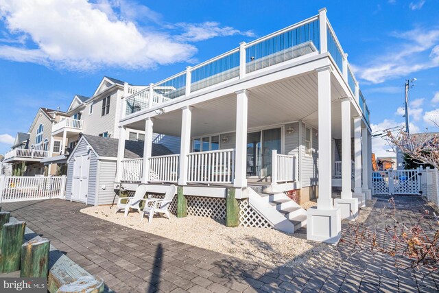 1427 Paul Blvd, Manahawkin, NJ 08050 - view of home's exterior featuring fence, a porch, a balcony, an outbuilding, and a gate