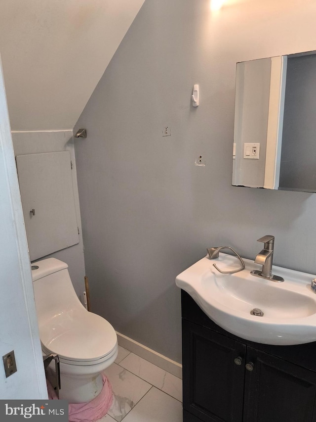 bathroom featuring lofted ceiling, vanity, and toilet