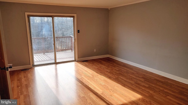 unfurnished room with hardwood / wood-style floors and ornamental molding