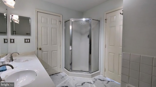 bathroom with vanity, a shower with shower door, and tile walls