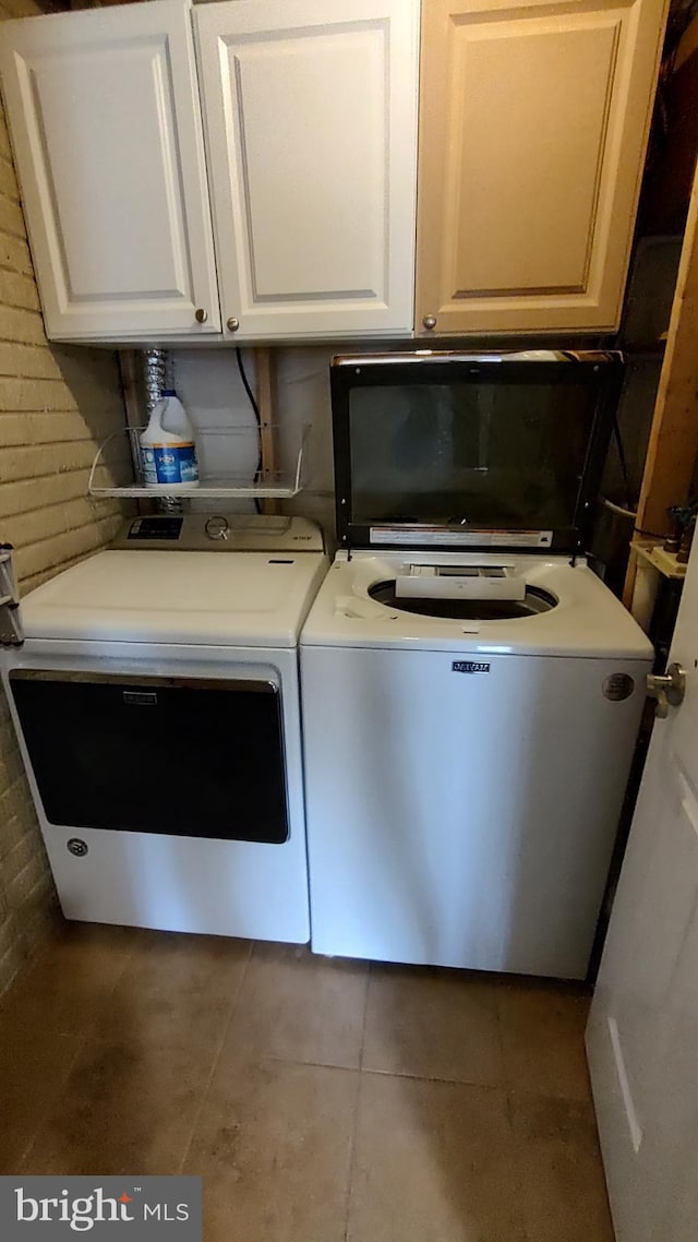 washroom with cabinets, tile patterned flooring, and washer and dryer