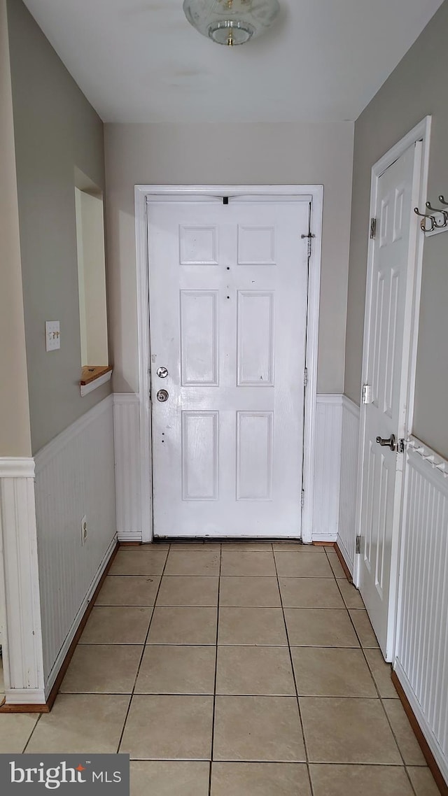 doorway to outside with light tile patterned floors