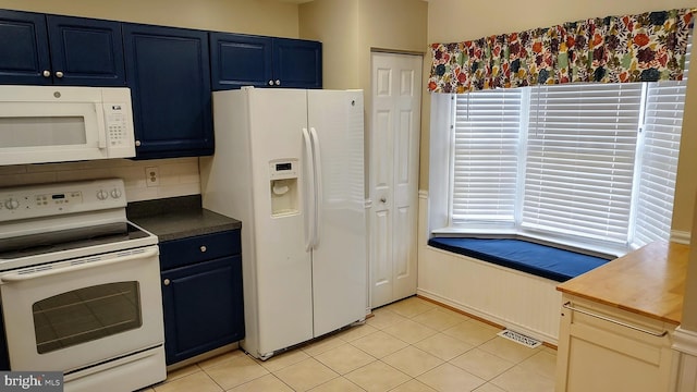 kitchen featuring blue cabinetry, light tile patterned floors, white appliances, and backsplash