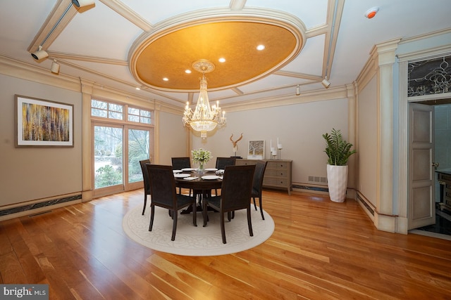 dining space with a notable chandelier, wood finished floors, visible vents, and crown molding