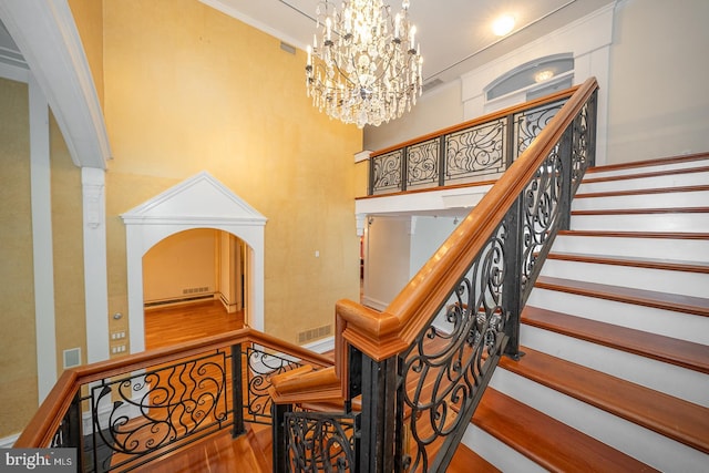 stairs with visible vents, ornamental molding, and wood finished floors