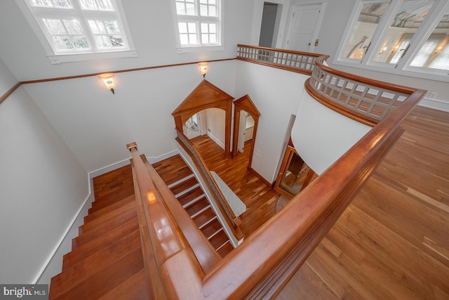 stairway with baseboards and wood finished floors