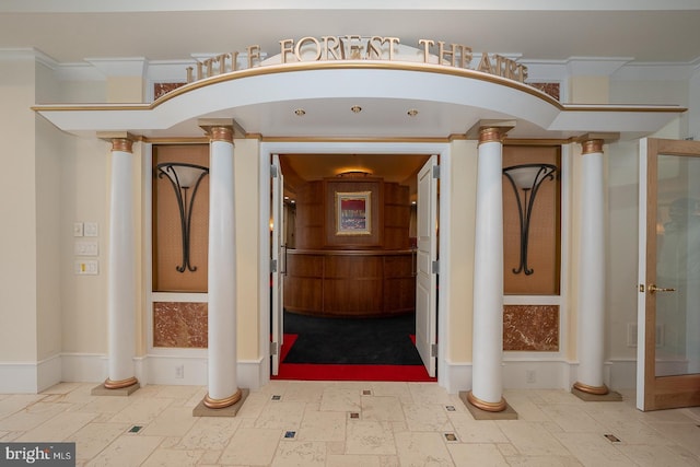 interior space featuring ornate columns and stone tile flooring