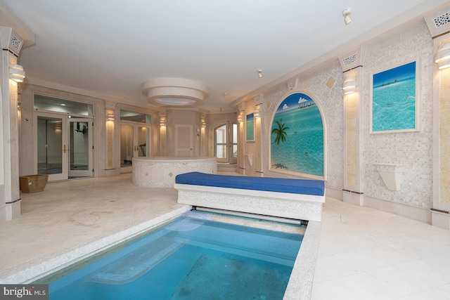 view of swimming pool featuring elevator, french doors, and a swimming pool