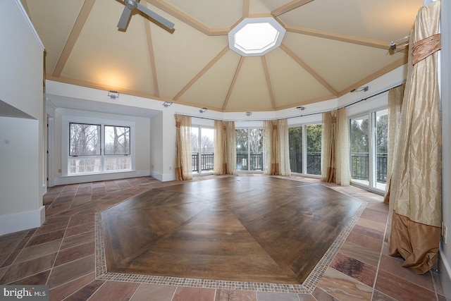 unfurnished living room featuring baseboards, high vaulted ceiling, and ceiling fan