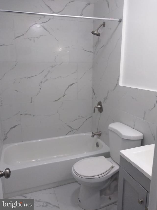 full bathroom with vanity, toilet, tiled shower / bath, and tile walls