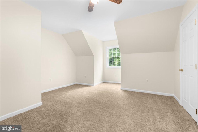 additional living space featuring light carpet, ceiling fan, and vaulted ceiling