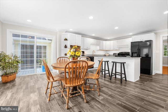 dining space featuring wood-type flooring and ornamental molding