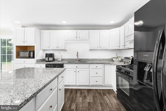 kitchen with black appliances, white cabinets, sink, dark hardwood / wood-style floors, and light stone countertops