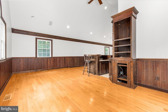 unfurnished living room featuring light hardwood / wood-style floors, ceiling fan, and ornamental molding