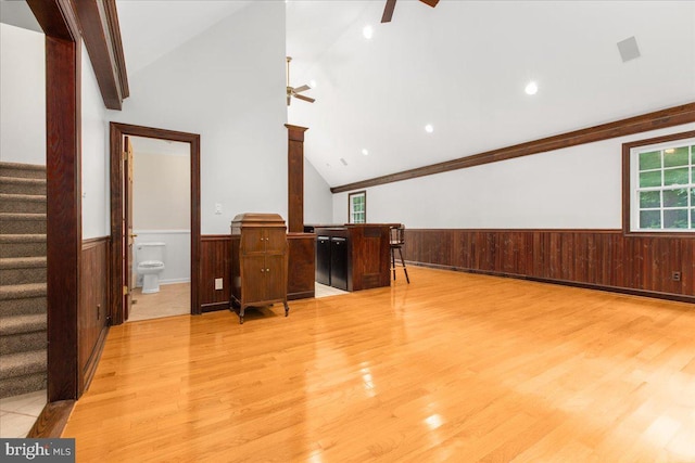 interior space featuring ceiling fan, light wood-type flooring, ornamental molding, and vaulted ceiling