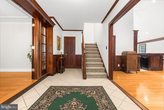 foyer featuring tile patterned flooring, ornamental molding, and wooden walls