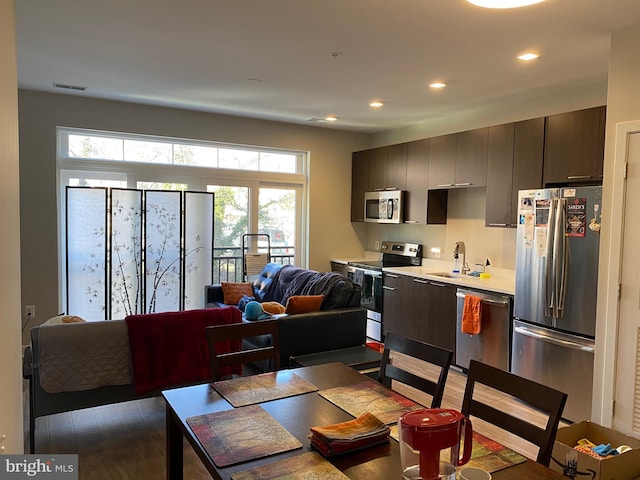 dining space with sink, hardwood / wood-style flooring, and plenty of natural light