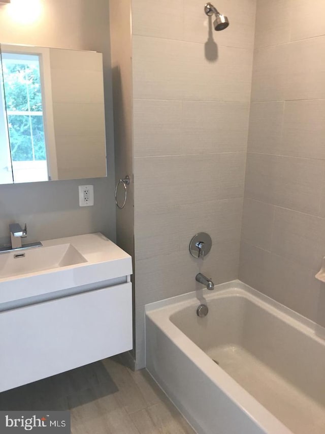 bathroom with vanity and tiled shower / bath