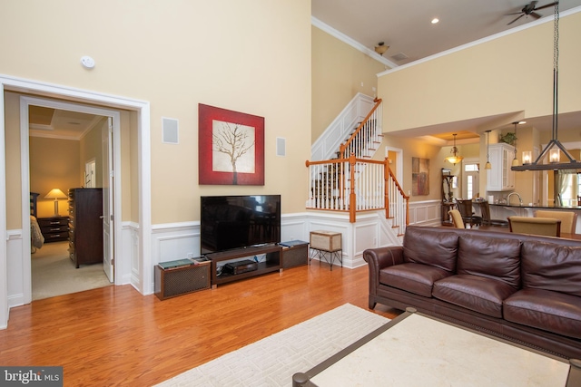 living room with hardwood / wood-style floors, ceiling fan, ornamental molding, and sink