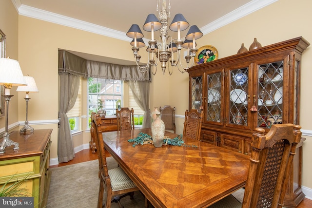 dining room with hardwood / wood-style flooring, a notable chandelier, and crown molding