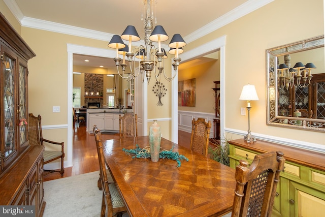 dining space with hardwood / wood-style flooring and crown molding