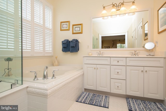 bathroom with tile patterned floors, tiled tub, and vanity