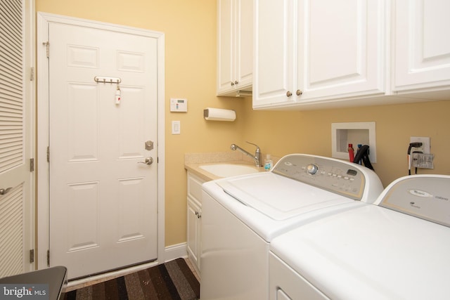 laundry room featuring cabinets, sink, and washing machine and clothes dryer