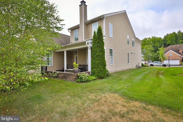 back of property with a yard and covered porch