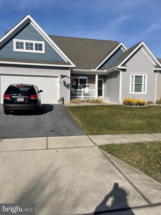 view of front facade with a garage, covered porch, and a front lawn