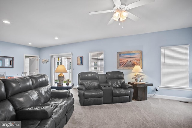 carpeted living room with ceiling fan